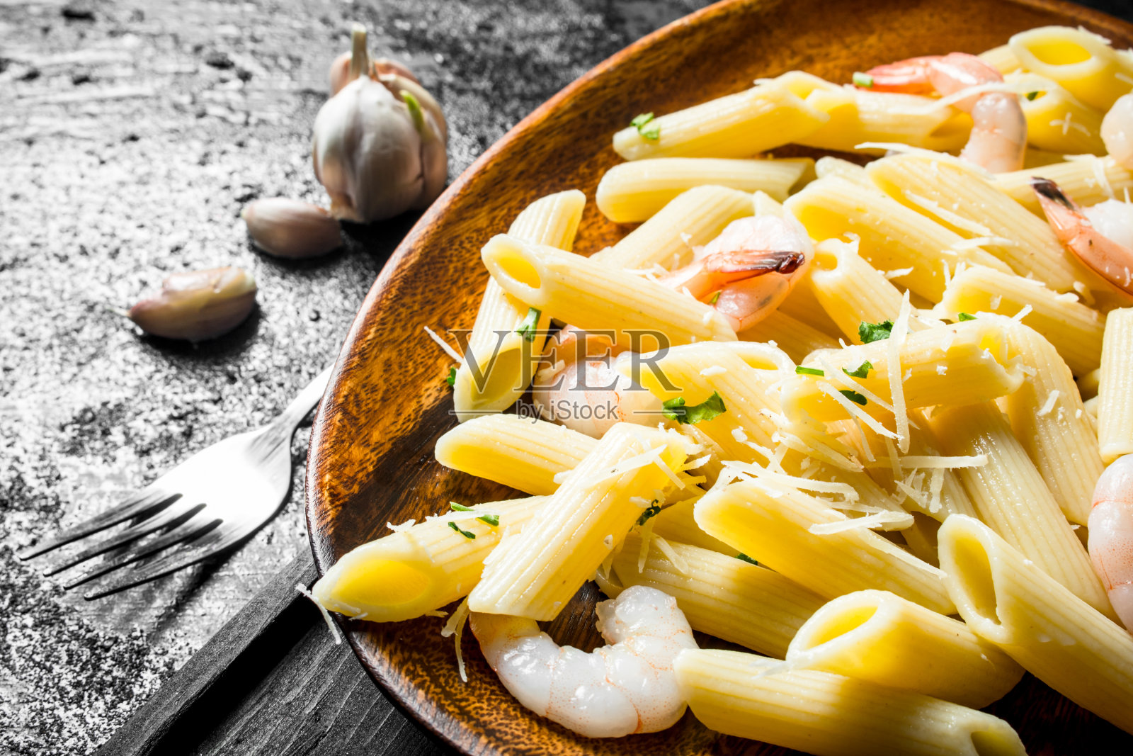 盘子里有虾和大蒜的意大利面。照片摄影图片