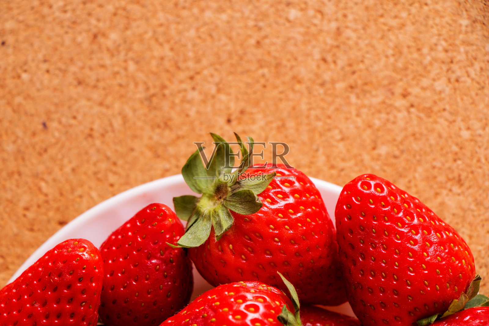 浆果，多汁，新鲜，美味的草莓，放在白色的盘子上，放在木桌上照片摄影图片