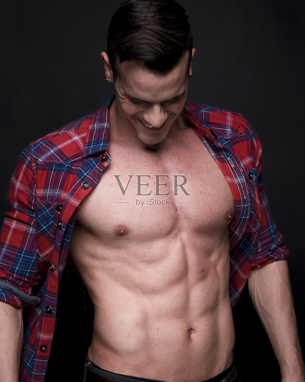 非常有吸引力的男子谁穿着一件解开的法兰绒衬衫和感觉性感照片摄影图片