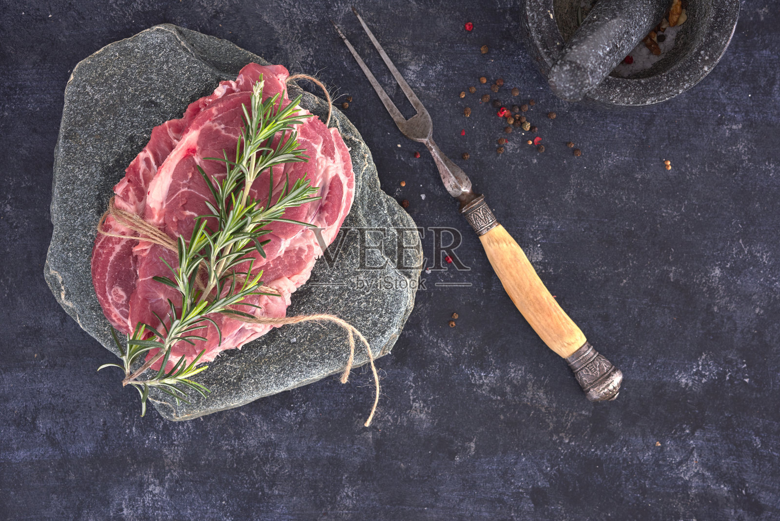 生肉牛排在黑暗的背景。复制空格文本概念。新鲜的迷迭香。照片摄影图片