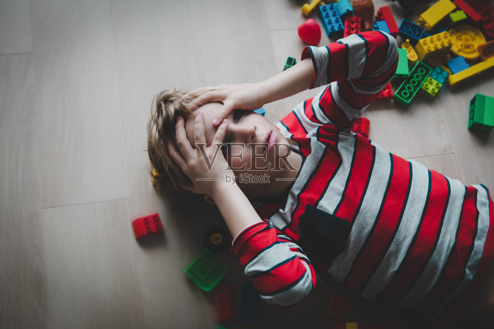 儿童厌倦玩耍，玩具散落一地照片摄影图片