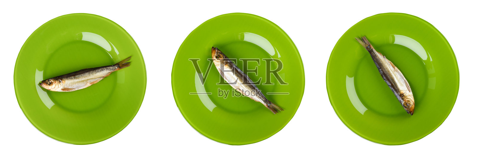 拼贴画。冷熏制的鲱鱼放在绿色的盘子里，孤立在白色的背景上。熏制成金黄色的鲱鱼。照片摄影图片