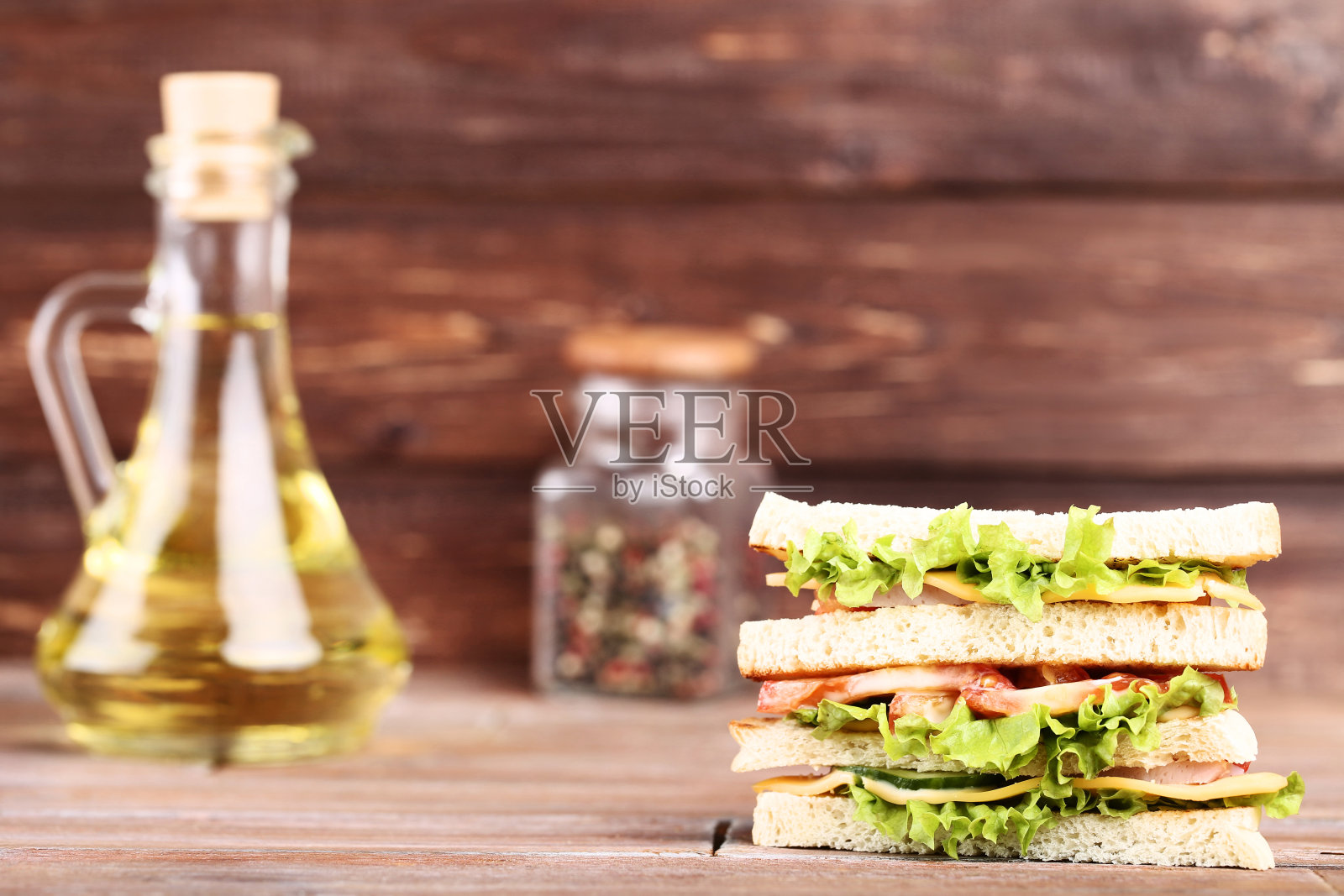 美味的三明治与油瓶在棕色的木制背景照片摄影图片
