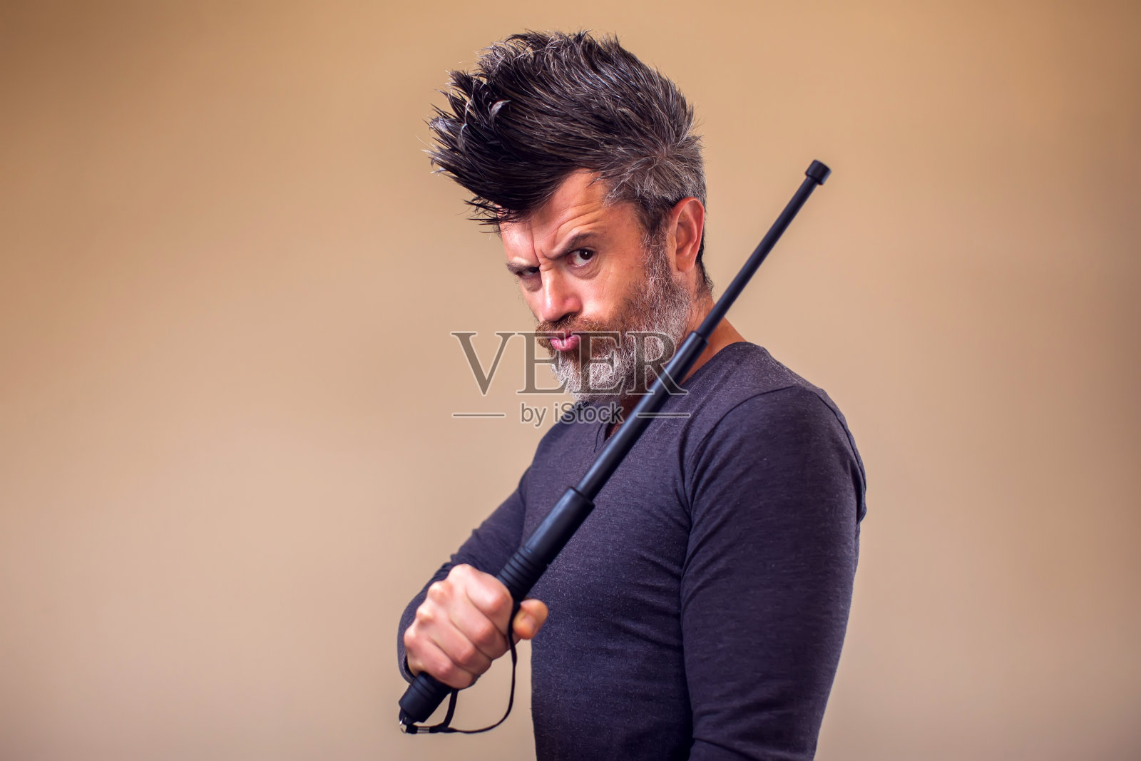 蓄着胡子的愤怒男子与tonfa。人,情感概念照片摄影图片