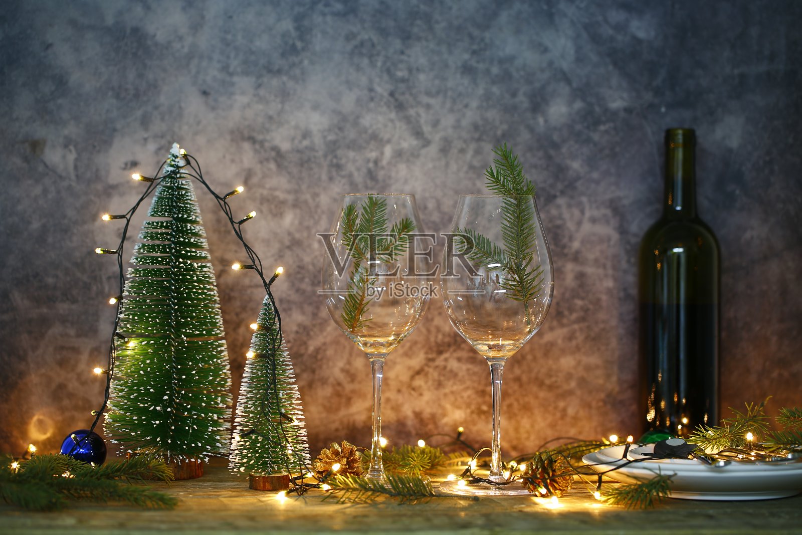 餐桌上的红酒和圣诞树。照片摄影图片