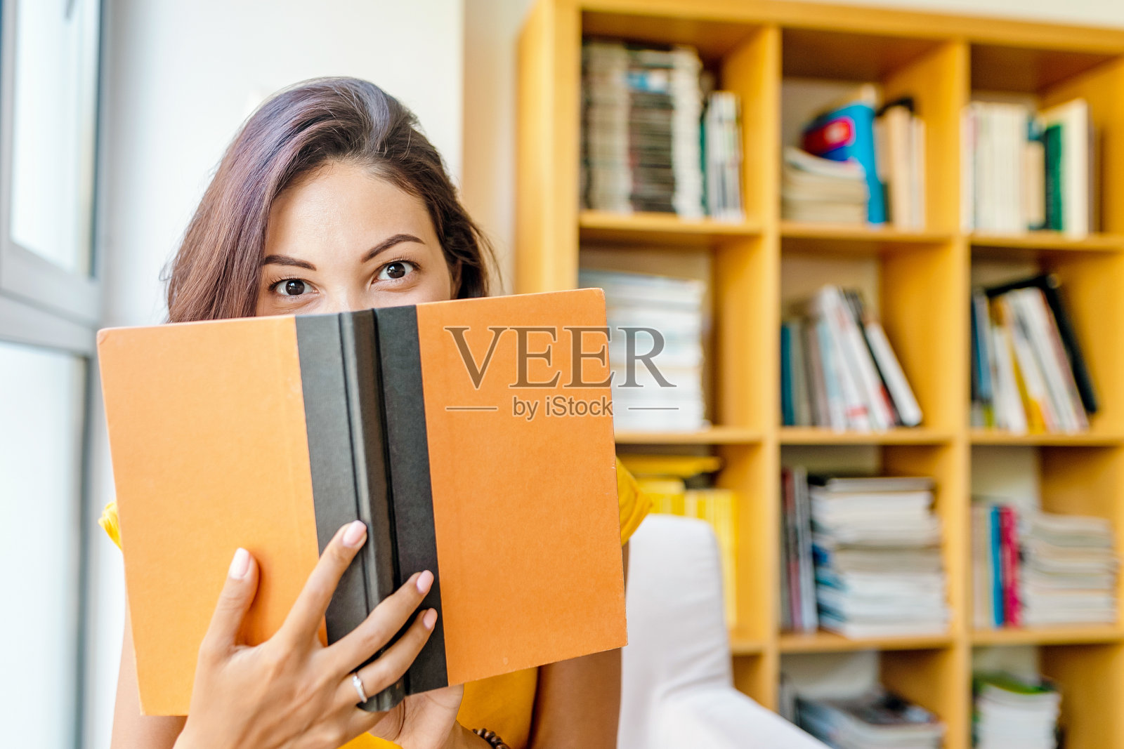 亚洲混血女性在图书馆看书，教育和生活理念照片摄影图片