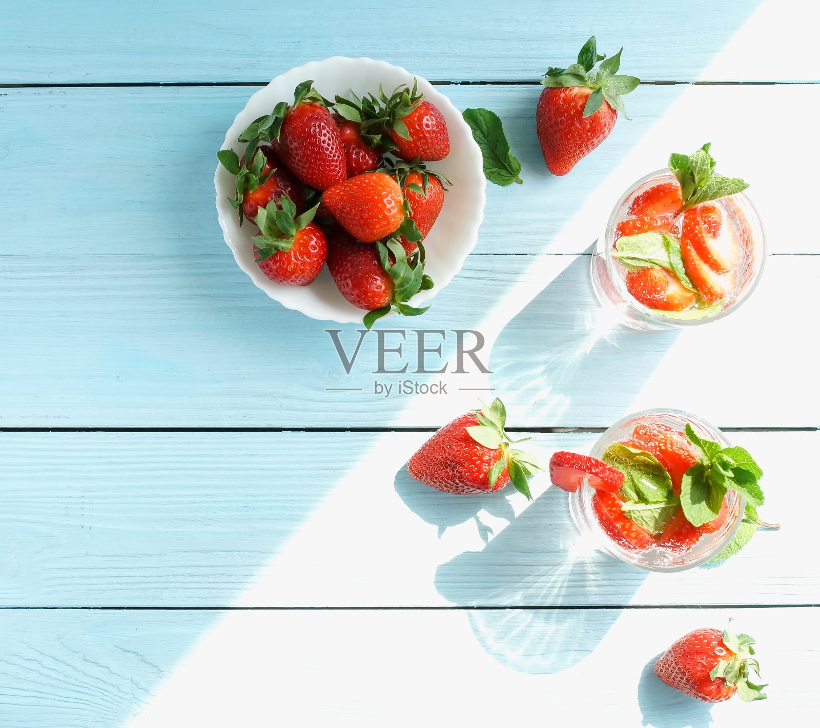 蓝色的木质表面，桌子，背景，搭配新鲜的草莓和薄荷，清凉的夏日饮品。本空间照片摄影图片