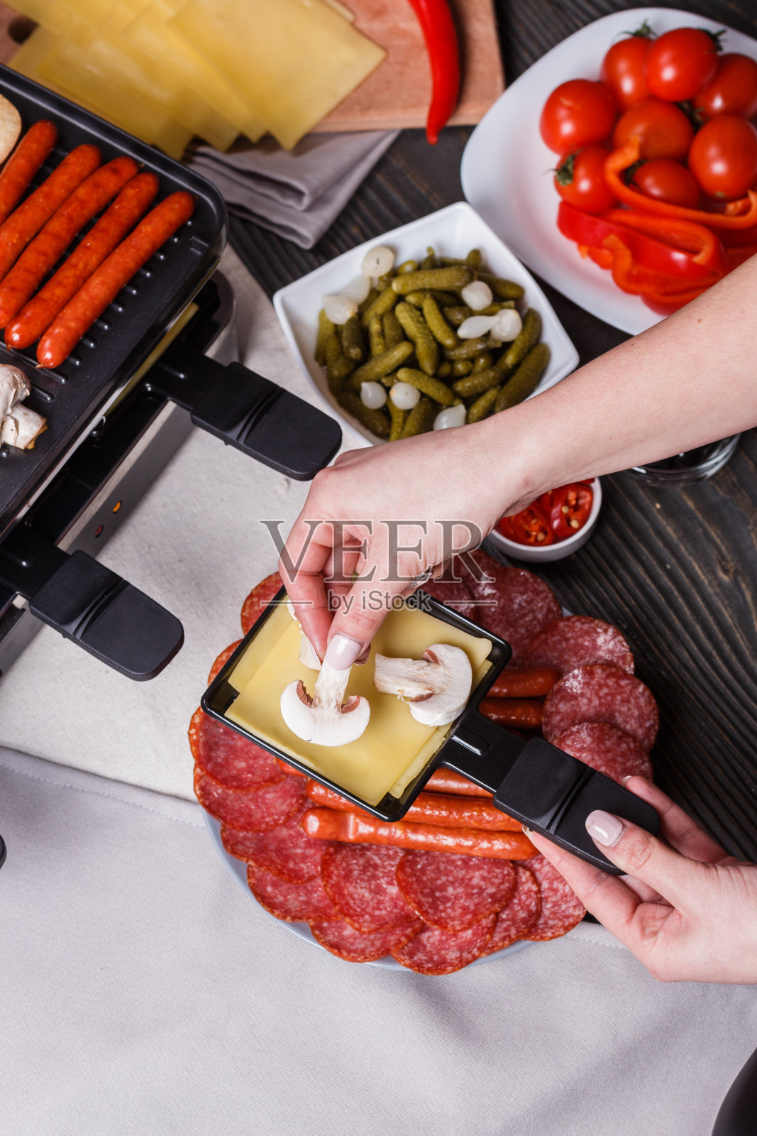 一位年轻的女士正在准备一种传统的瑞士奶酪照片摄影图片