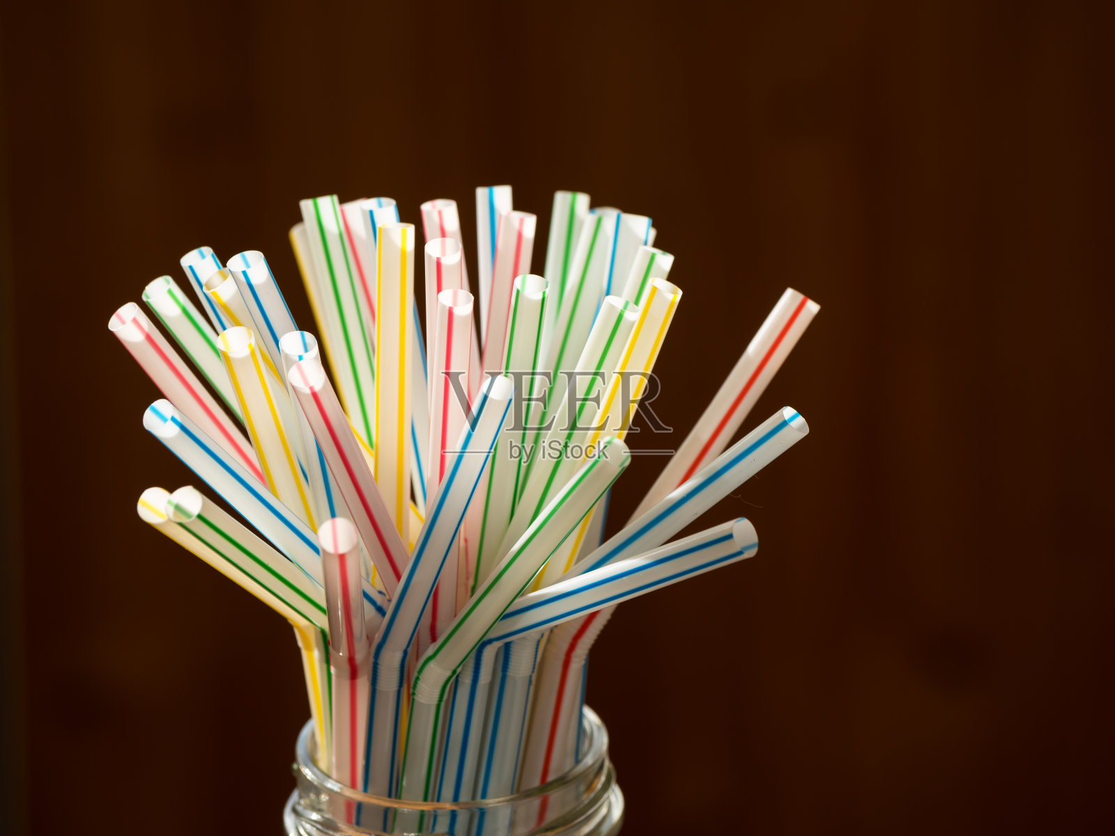 多色柔性吸管在黑暗的背景。照片摄影图片