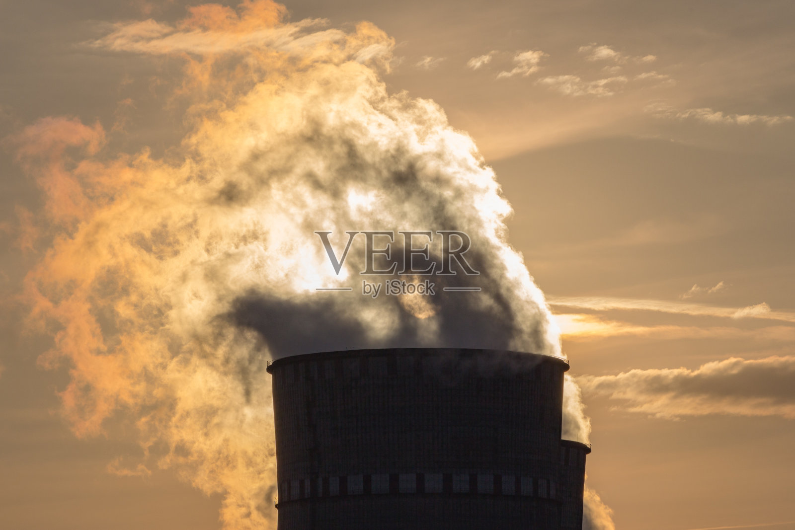 工业排气管映衬着天空和日落时的烟雾照片摄影图片