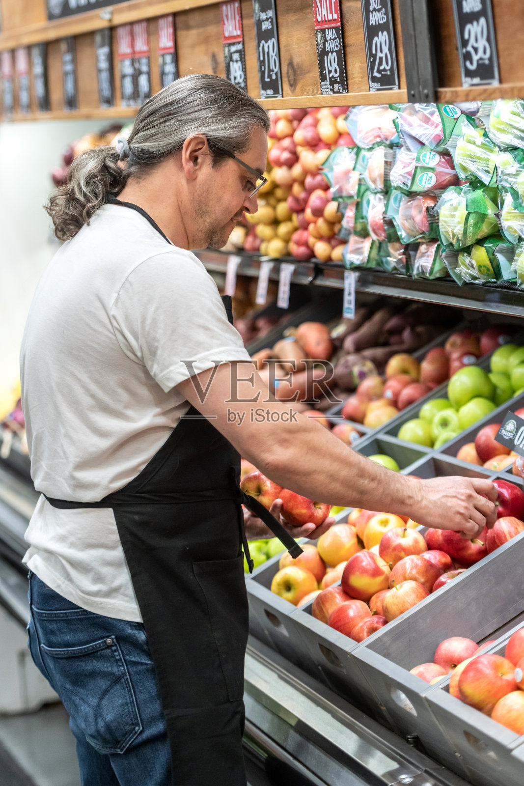 在超市水果区工作的成熟男人照片摄影图片