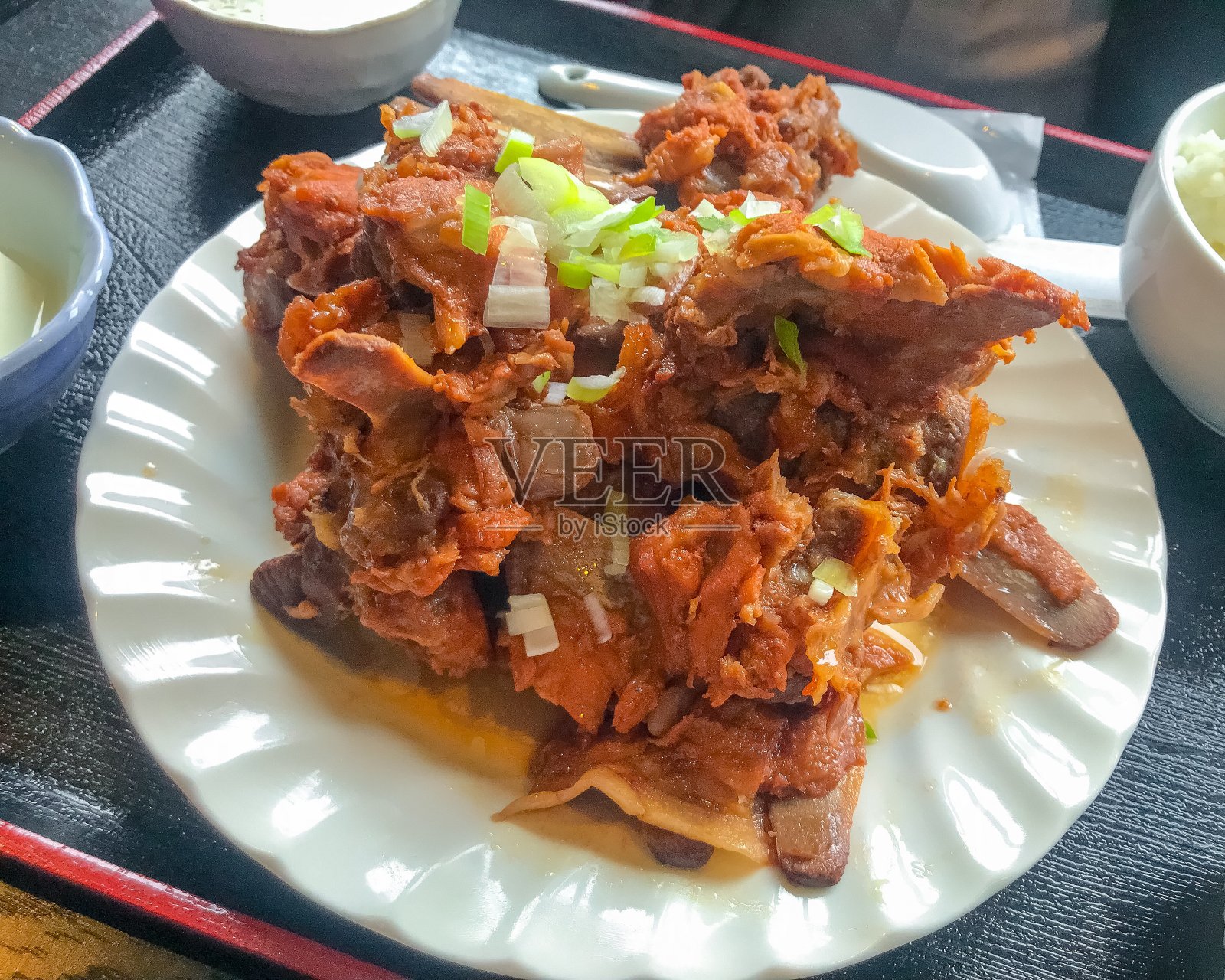 红烧猪脊肉，盛在盘子里照片摄影图片