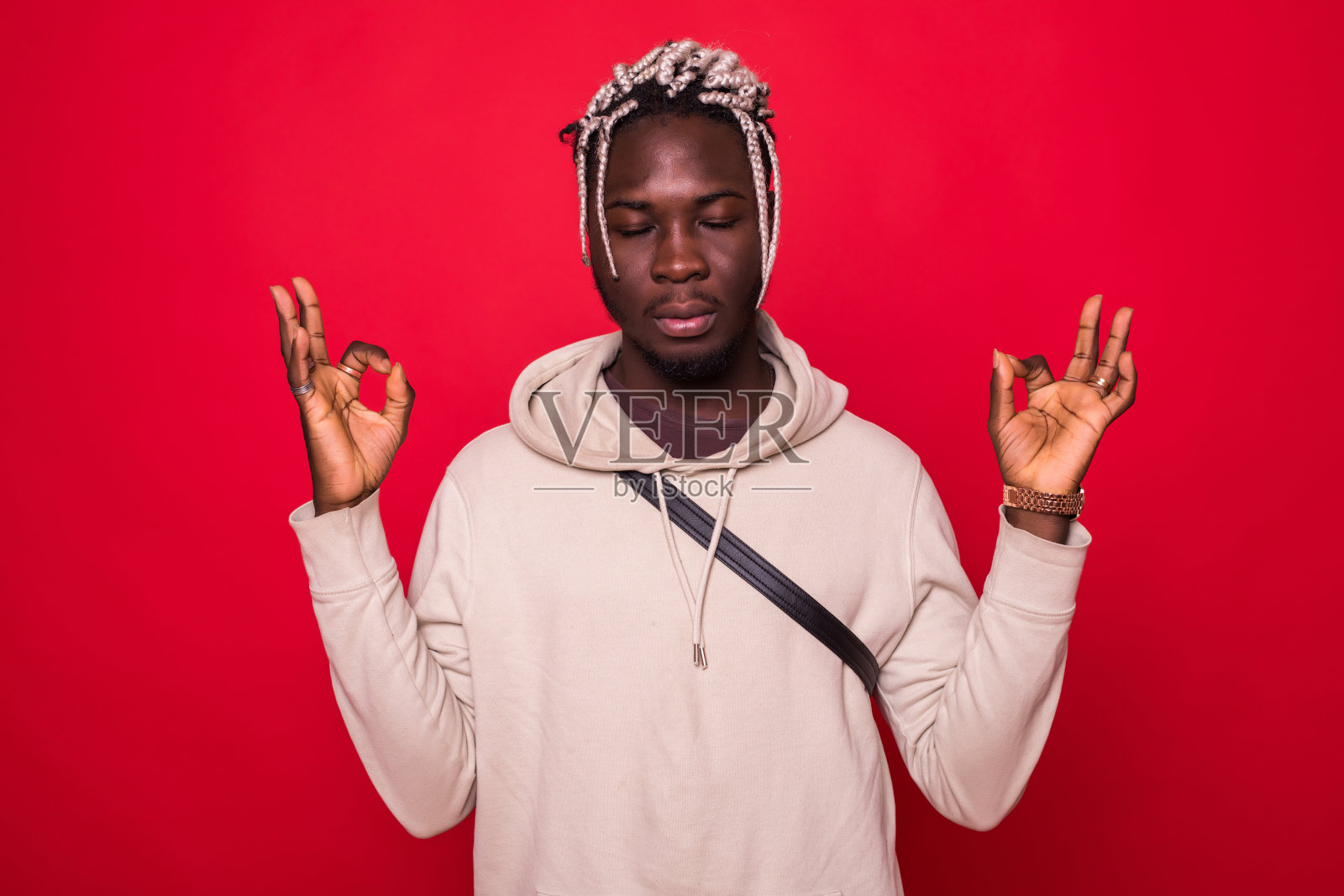 肖像英俊的年轻人，闭上眼睛，在禅修模式下，孤立红色背景。减压技术的概念是深呼吸。人类积极的情绪、面部表情、表情、感觉照片摄影图片