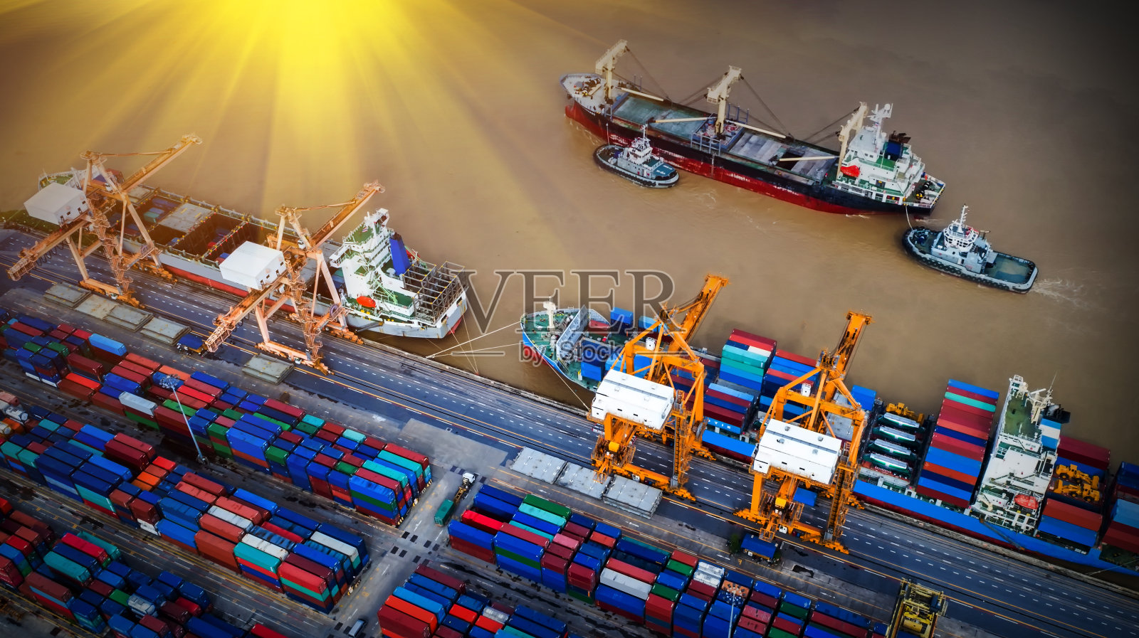 物流与运输的集装箱货轮和货机与工作起重机桥在日出船厂，物流进出口和运输行业背景照片摄影图片