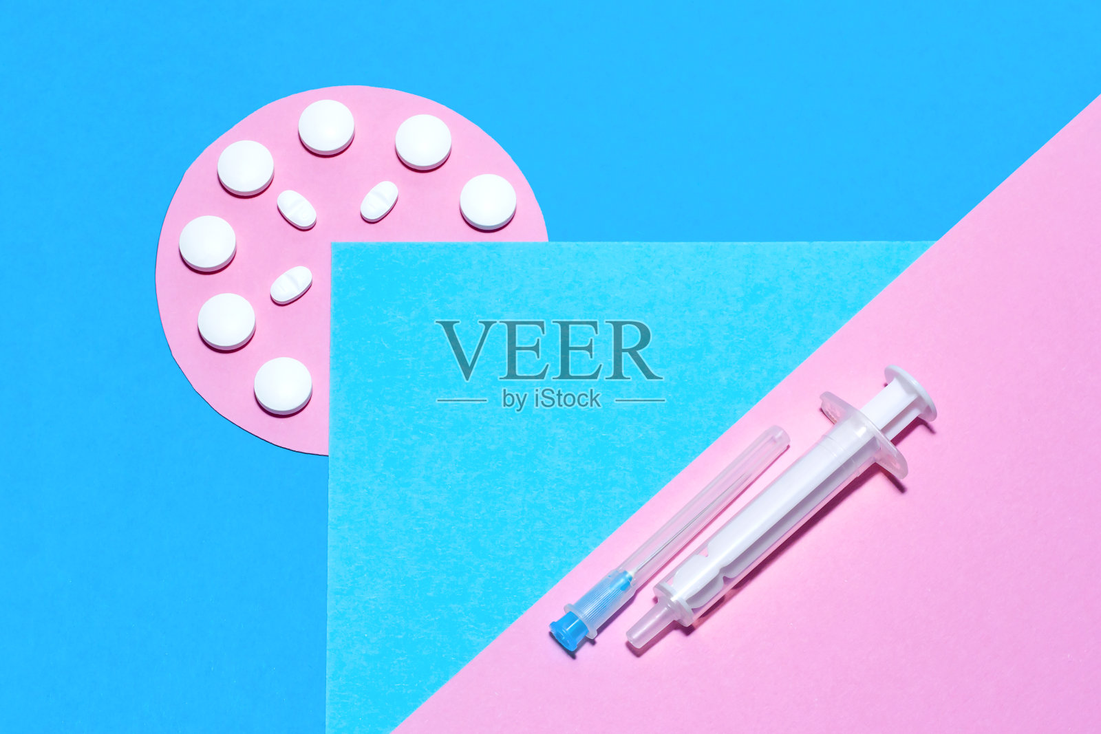 医疗用品和药丸，极简主义的平面躺着，在蓝色和粉色的纸背景上留有拷贝空间。照片摄影图片