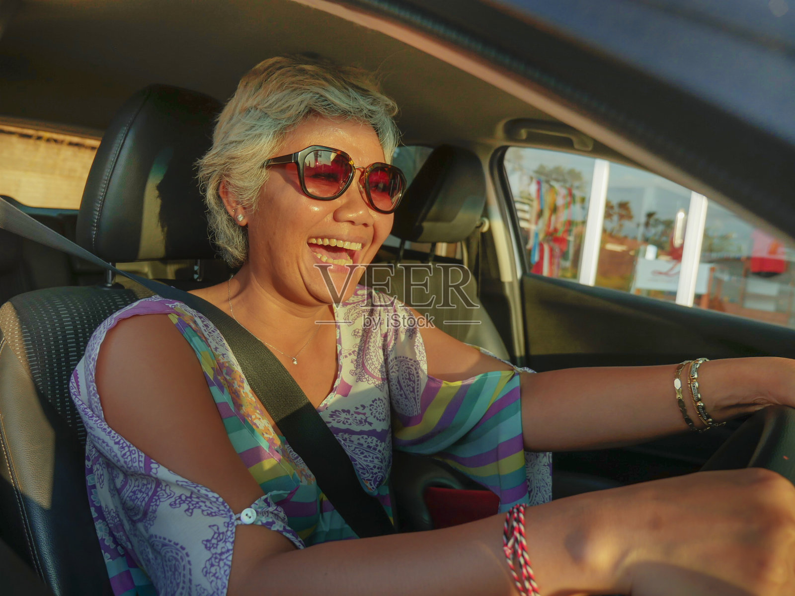 生活方式夏季肖像中年快乐和有吸引力的亚洲印尼女人驾驶左手车微笑愉快和自由在一个阳光明媚的日子在汽车租赁和旅游的概念照片摄影图片