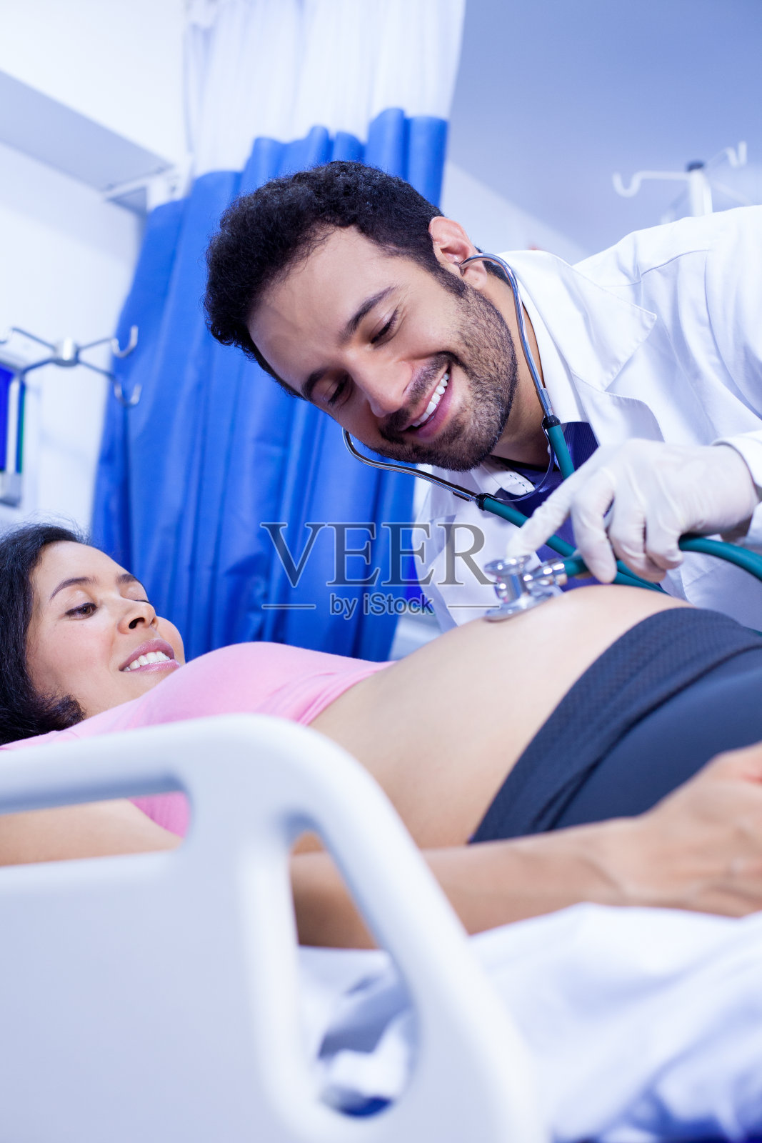 拉丁裔医生向孕妇提供医疗咨询。照片摄影图片