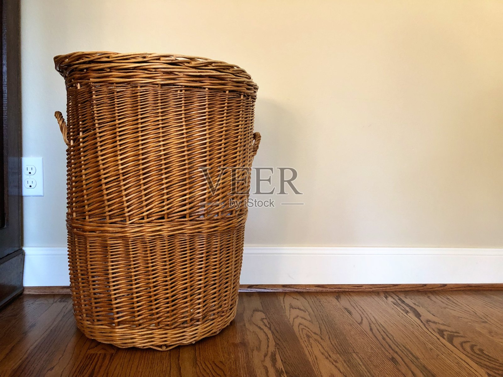 硬木地板上的柳条洗衣篮照片摄影图片