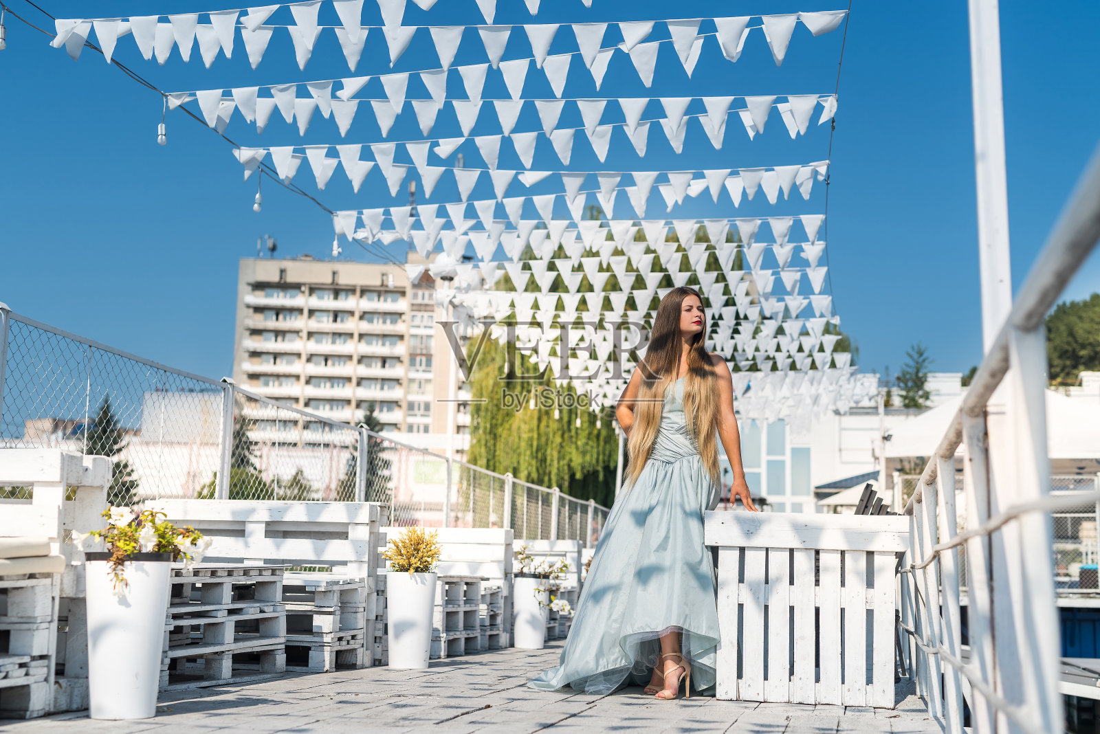 年轻漂亮的女人穿着衣服站在码头上照片摄影图片