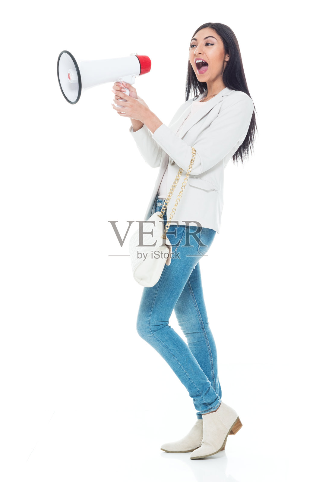 美丽的拉丁女性穿着夹克和牛仔裤-使用扩音器照片摄影图片