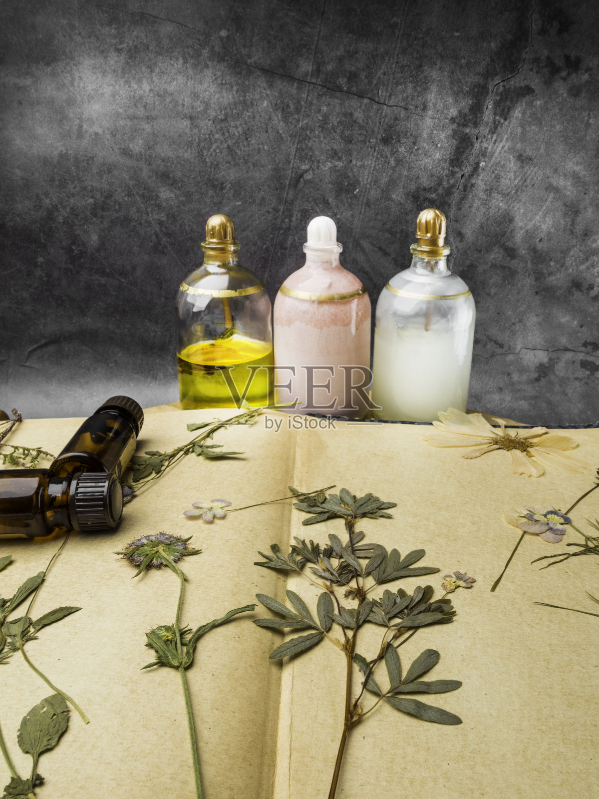 静物、健康、美容、spa概念。干花在旧纸上涂油。有选择性的重点照片摄影图片