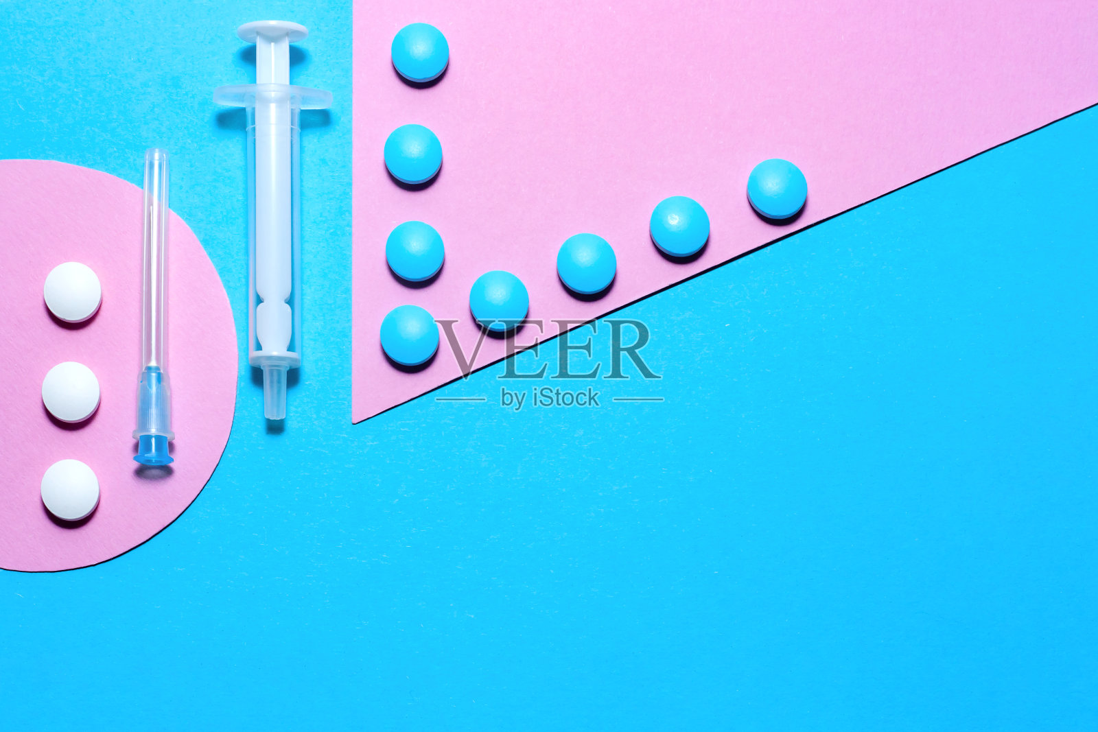 医疗用品和药丸，极简主义的平面躺着，在蓝色和粉色的纸背景上留有拷贝空间。照片摄影图片