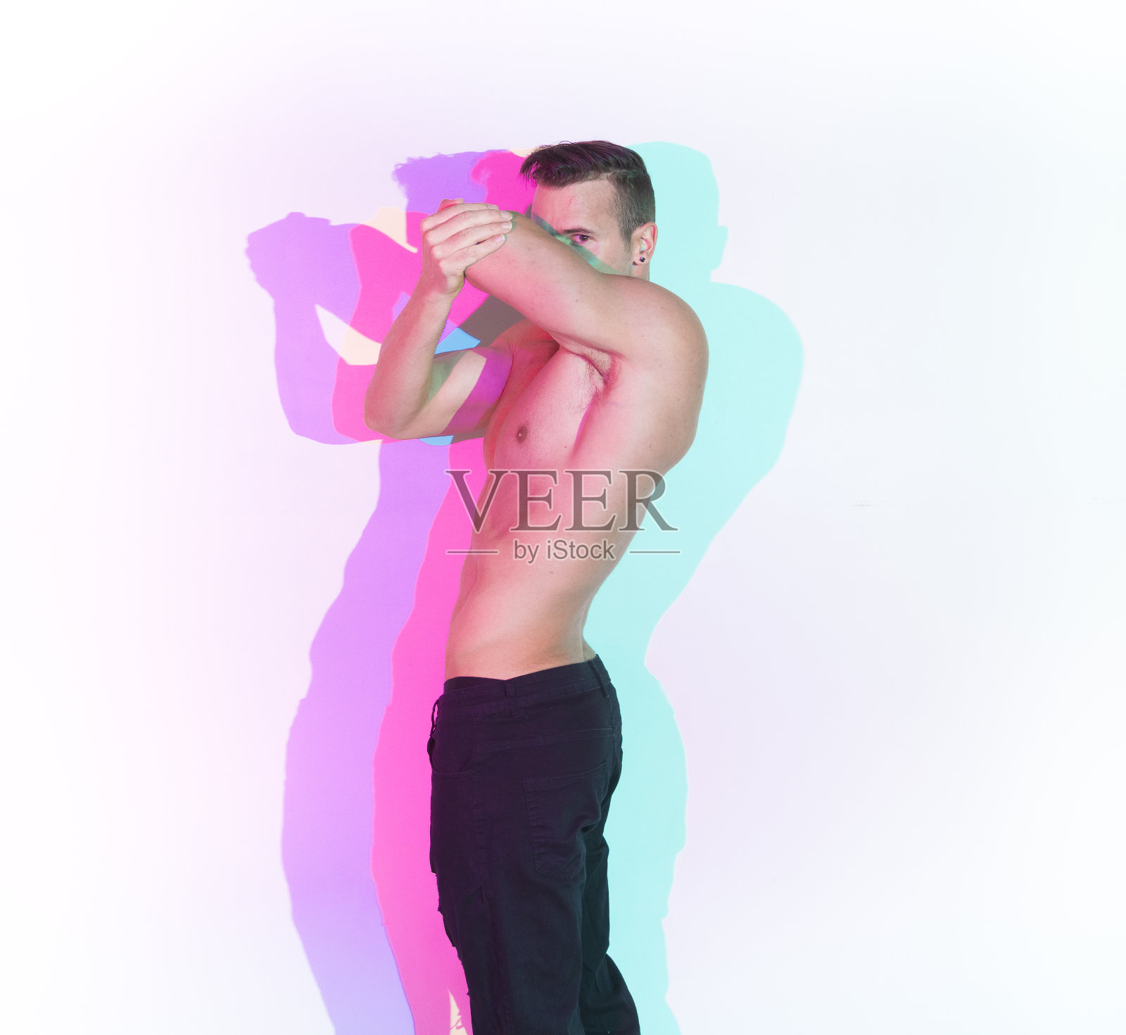 英俊的赤膊男子穿着黑色牛仔裤站在白墙前照片摄影图片