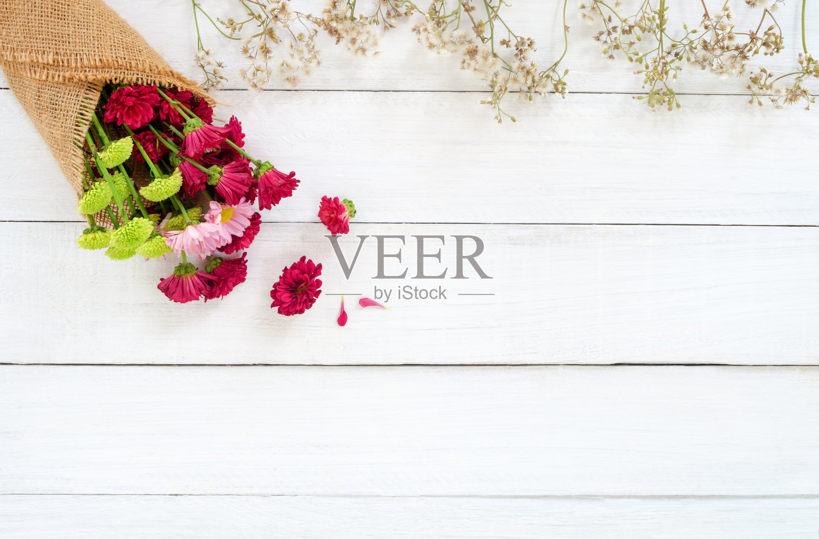 白色木质背景上的一束五颜六色的菊花和野花。照片摄影图片