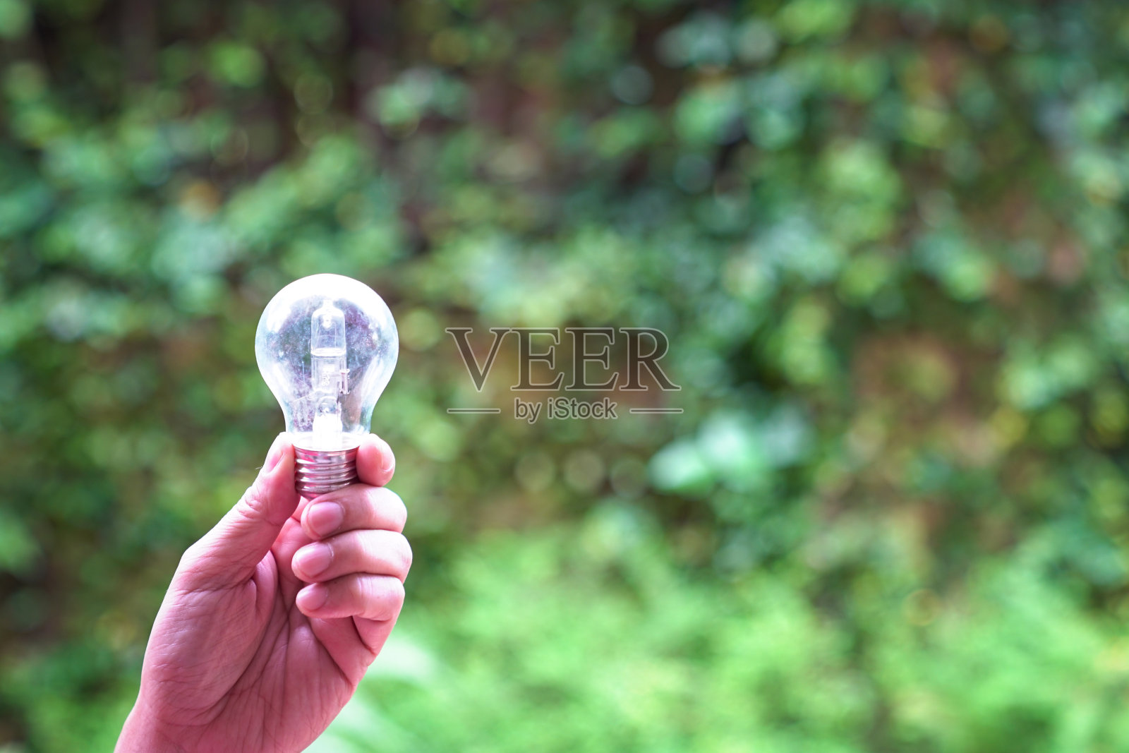 手里拿着一个灯泡照片摄影图片