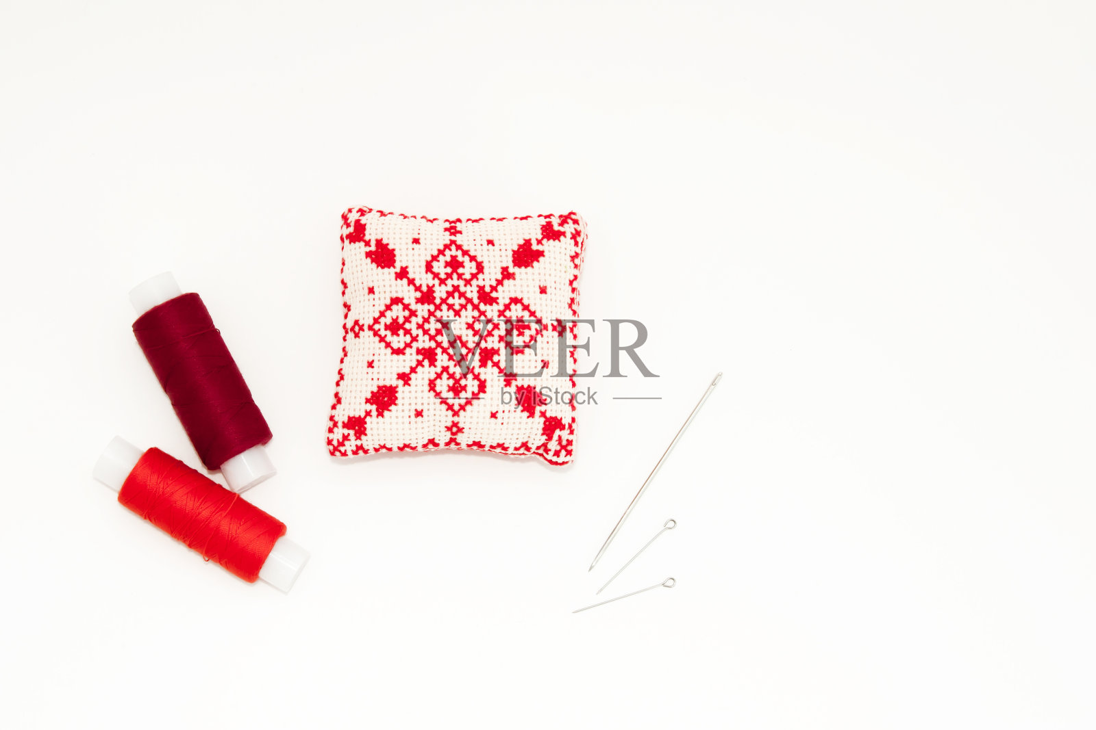 平躺与手工红色绣花针垫，线轴，别针，针，模拟，俯视图。布局模型在空白的白色背景刺绣，缝纫海报，横幅。文本的空白。照片摄影图片