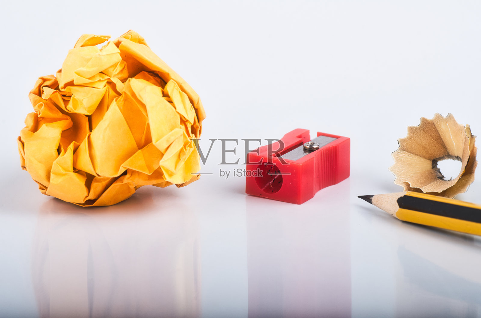 创意概念，铅笔与它的刨花，折皱纸和卷笔刀在白色的背景照片摄影图片