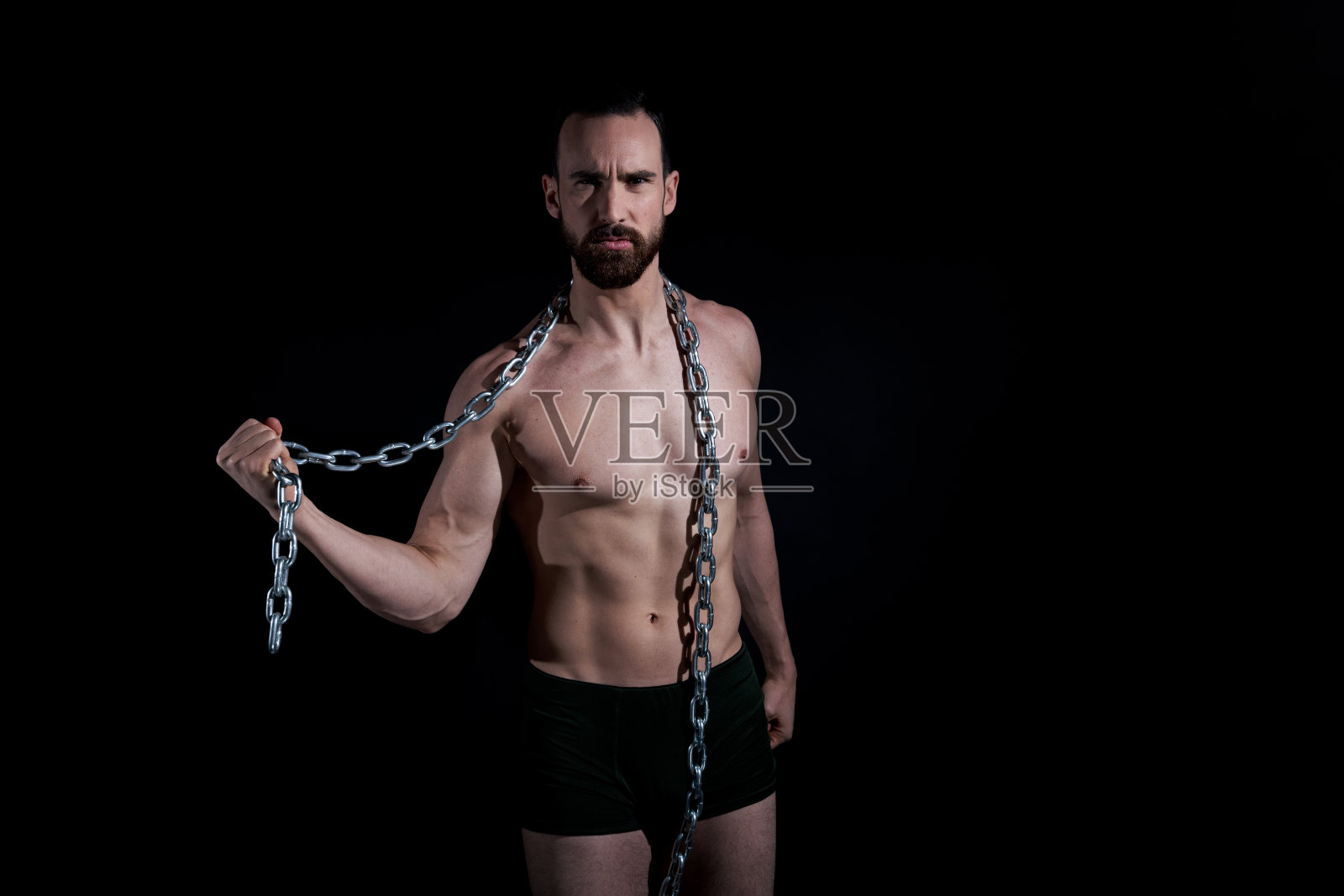 穿着内衣，拿着金属链子的帅哥照片摄影图片