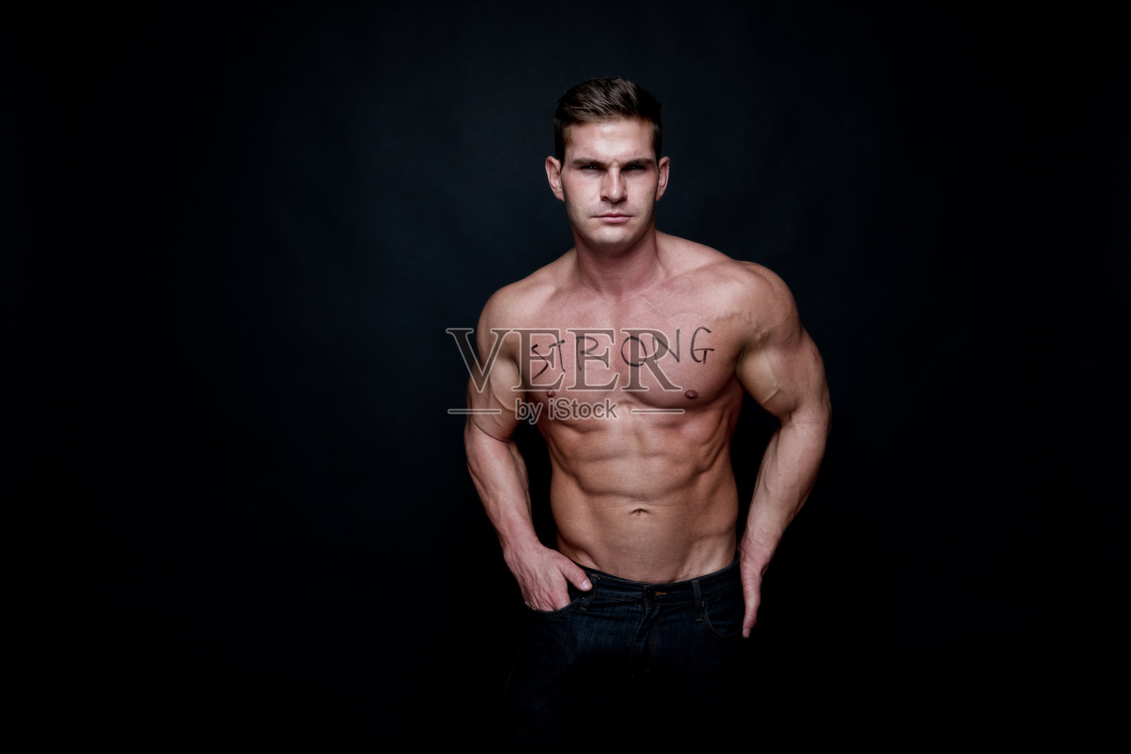 漂亮的肌肉男，胸前写着强壮照片摄影图片