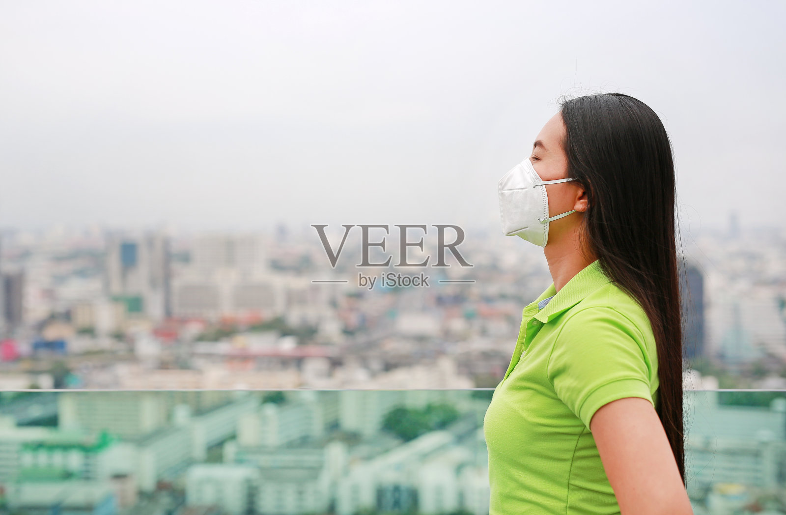 在曼谷，一名年轻的亚洲女性戴着防止pm2.5空气污染的口罩。泰国。减少空气污染的概念。照片摄影图片