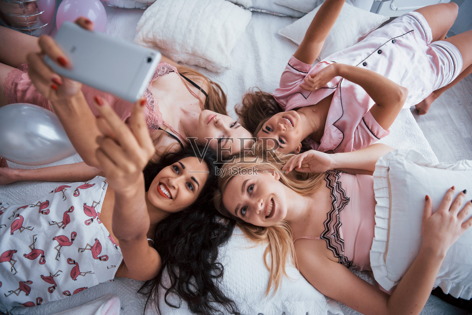 在单身派对上躺在床上与朋友自拍照片摄影图片