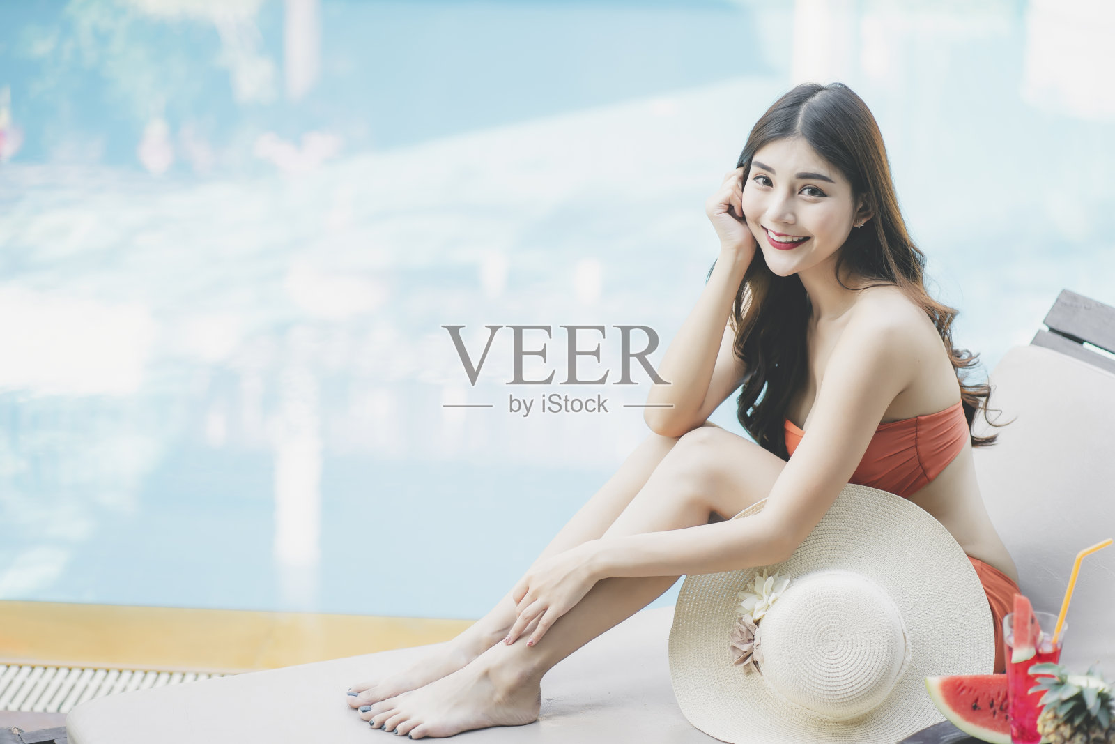 美丽的亚洲女人穿着比基尼在游泳池享受暑假。照片摄影图片