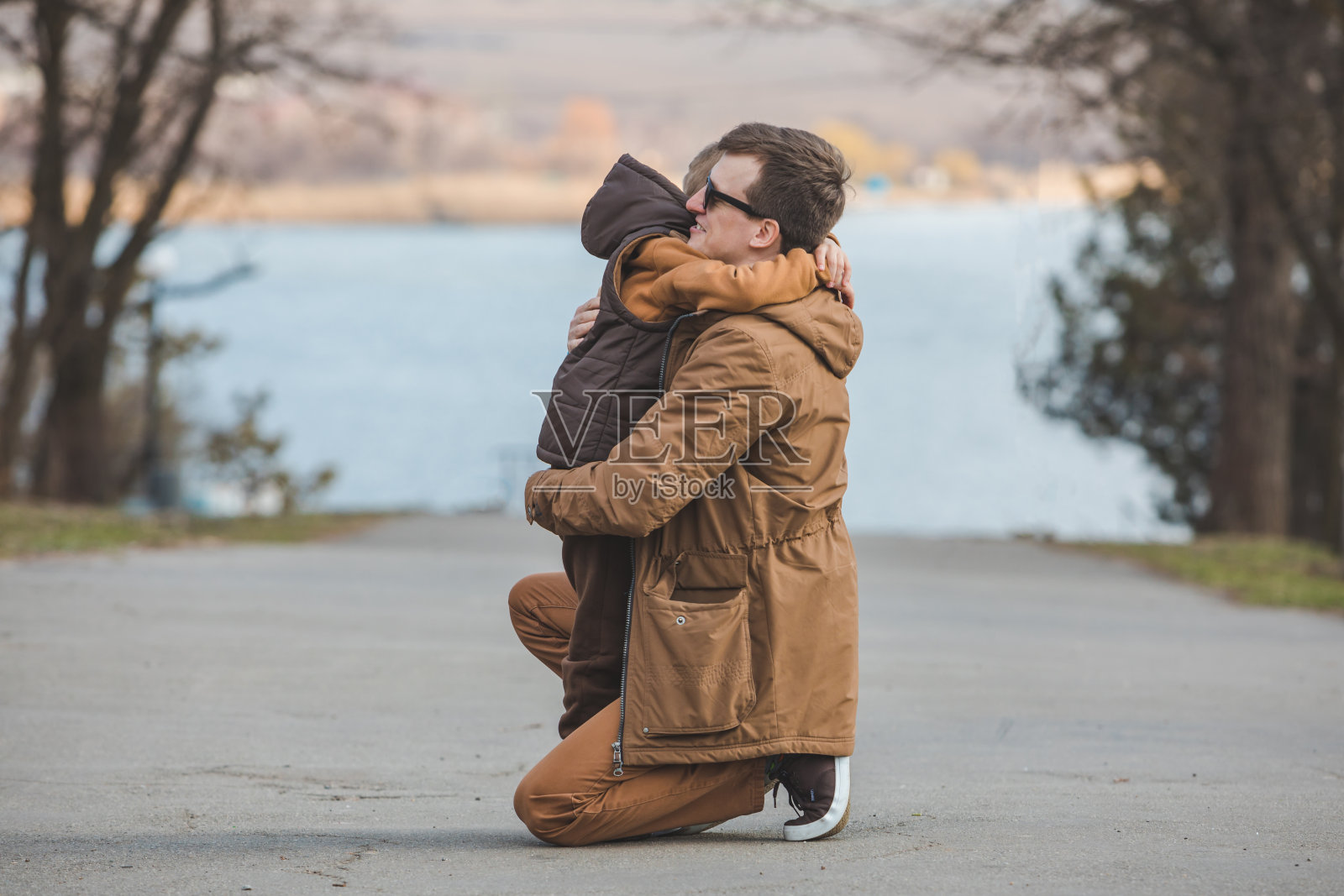 父亲在户外拥抱小儿子照片摄影图片