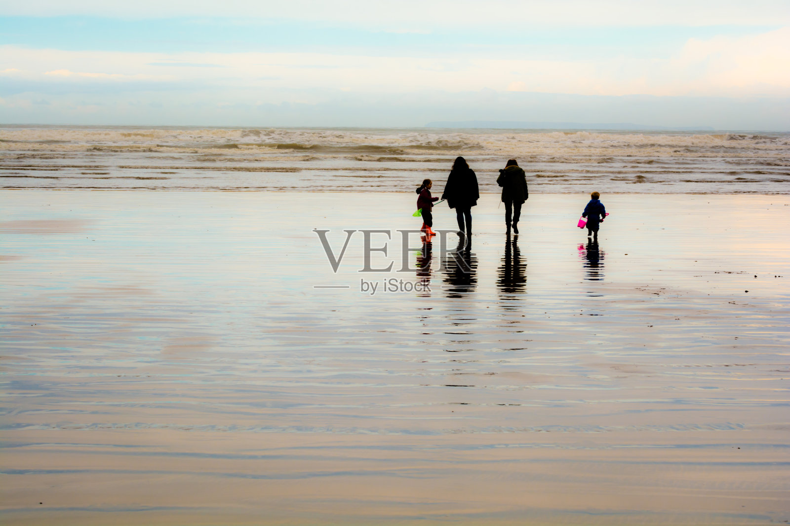 一家人在海滩上散步照片摄影图片
