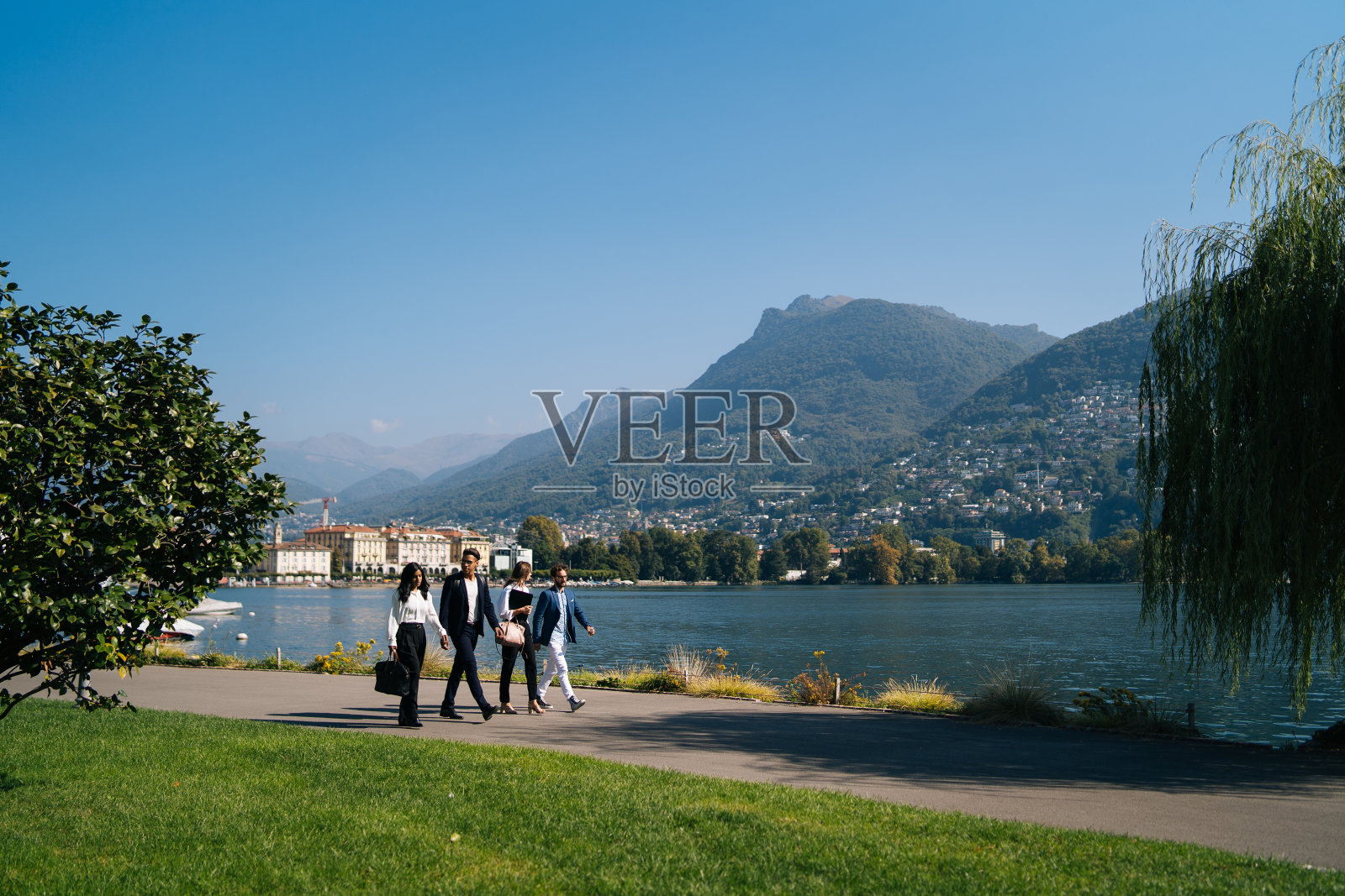 商人们沿着湖边的长廊散步照片摄影图片