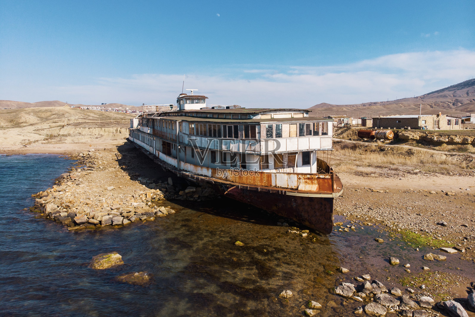 老旧的废弃生锈的船搁浅后，沉船很久以前海岸上的沙滩，鸟瞰图照片摄影图片