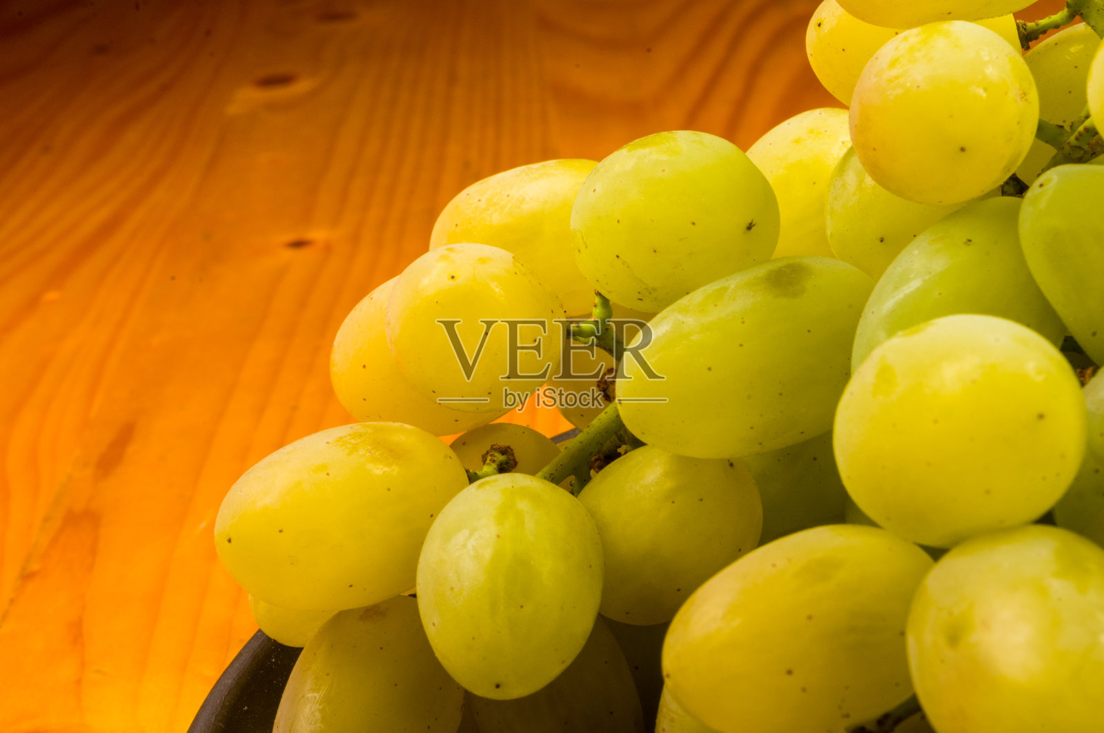 大刷子绿色葡萄在一个深色陶瓷盘子在木制的背景照片摄影图片