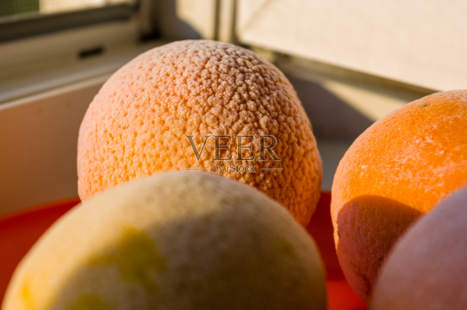 红色盘子上放着冰冻的橙子和柠檬，上面覆盖着霜照片摄影图片