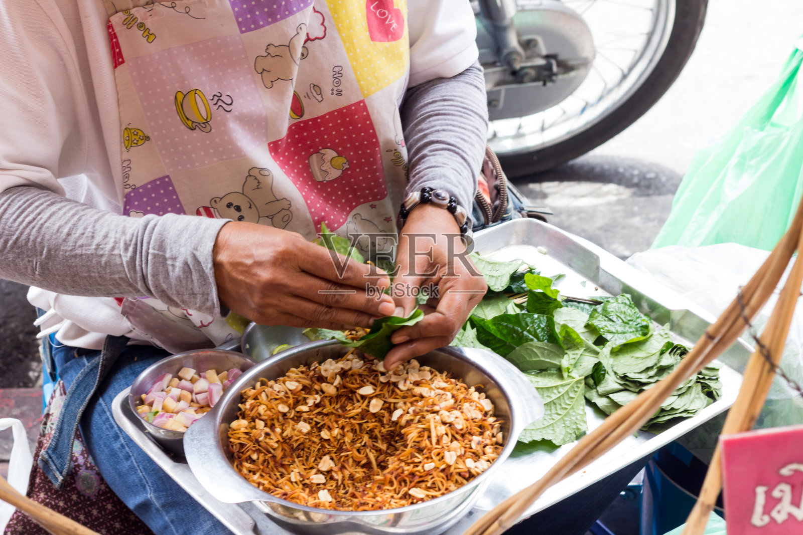 曼谷唐人街Yaowarat路，一名街头小贩正在制作一种传统的泰国小吃Miang Kam照片摄影图片