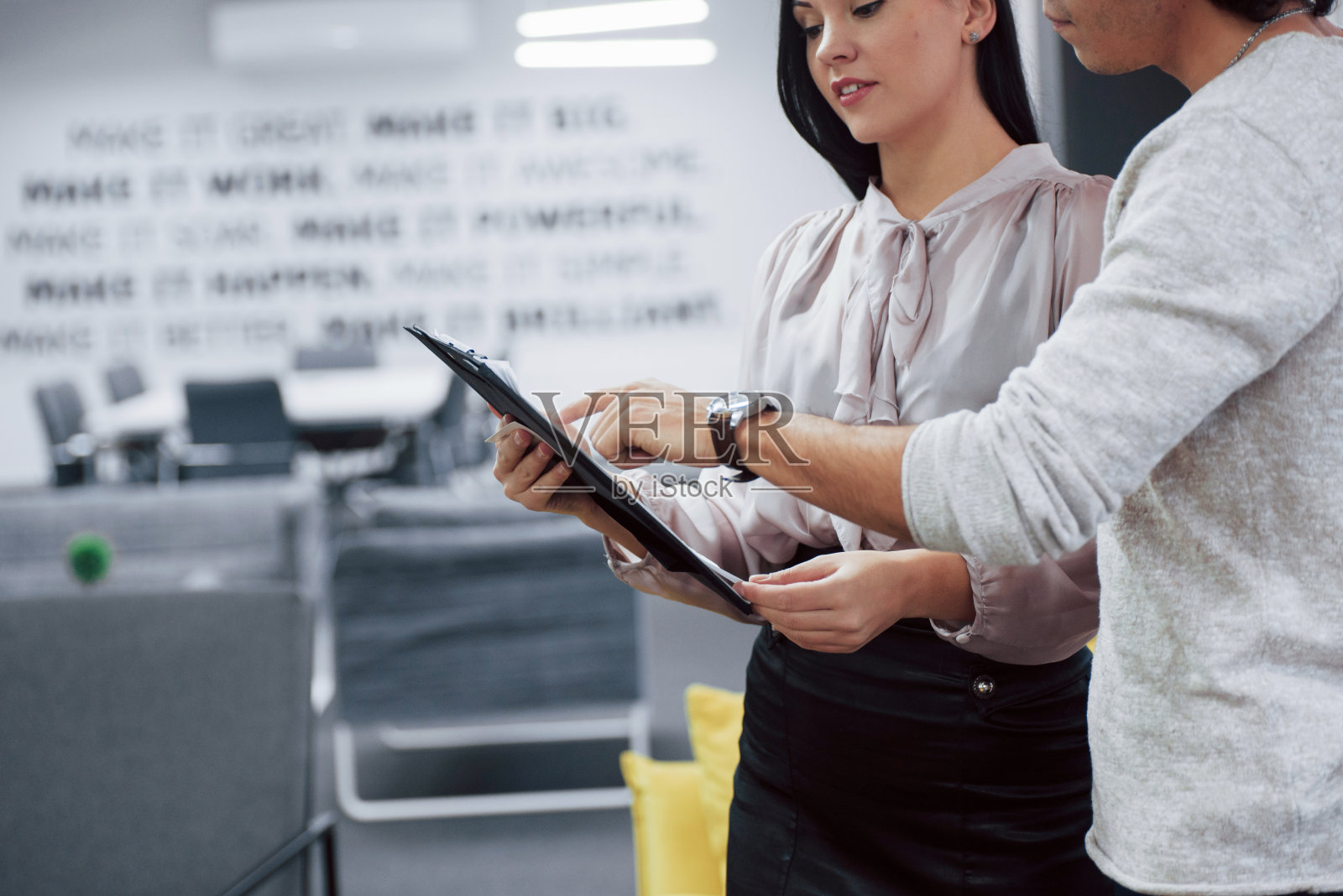 仔细看这份报告。现代办公室里快乐的同事，工作时面带微笑照片摄影图片