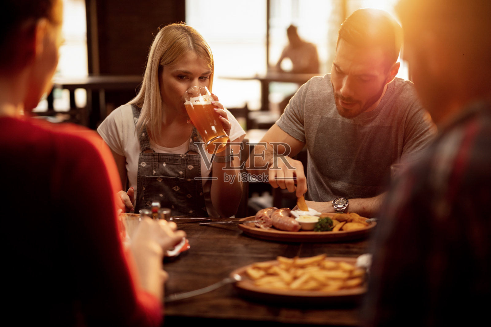 一群朋友在小酒馆吃午饭，喝啤酒。照片摄影图片