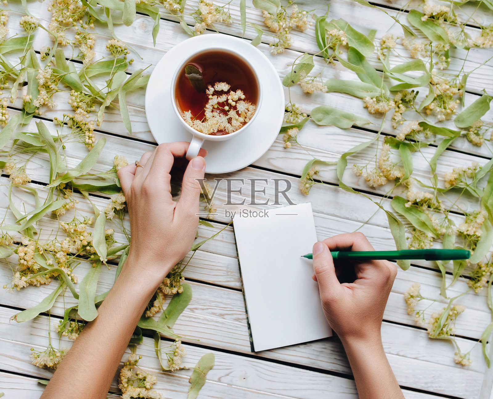 女医生给病人开了一个处方。流感、急性和呼吸道疾病。茶在一杯干酸橙花在木制的背景。照片摄影图片