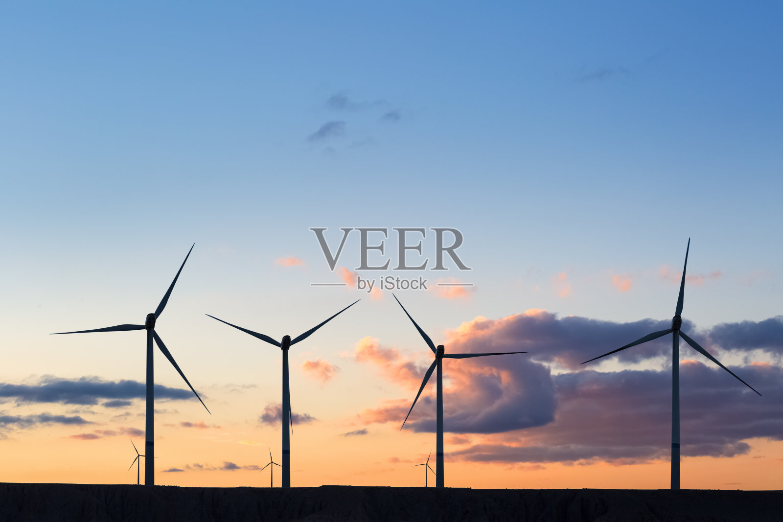 晚霞天空下风力发电机的剪影照片摄影图片