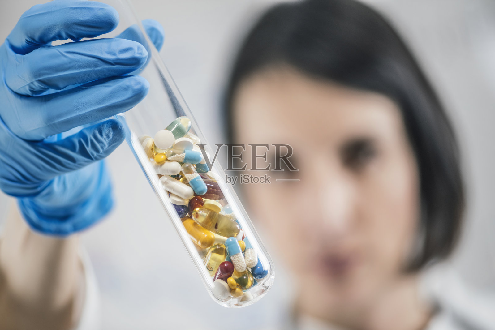 医药研究。装满彩色药丸的玻璃试管照片摄影图片