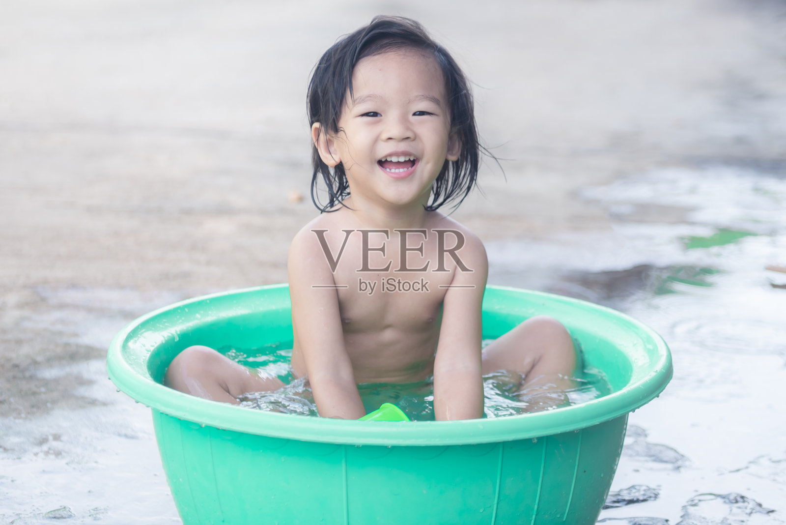 孩子们坐在盆里玩水玩得很开心照片摄影图片