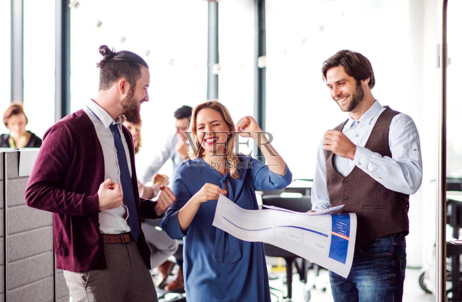 一群年轻的商务人士在办公室里表达兴奋。照片摄影图片